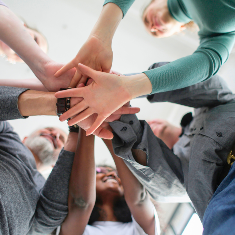 Gemeinsam helfen Verschränkte Hände von einer Gruppe Menschen